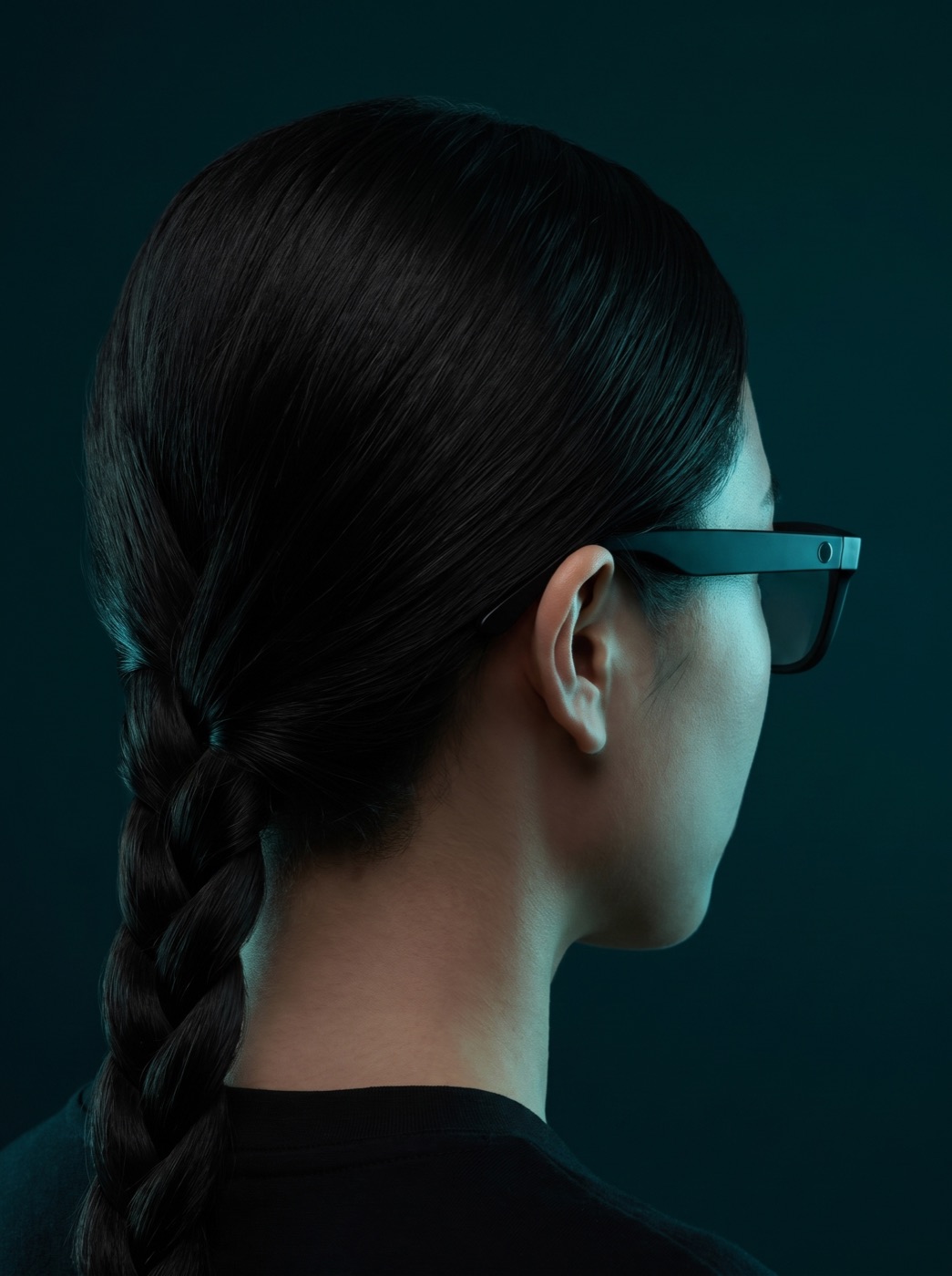 The back of a woman's head, wearing Glimpse Glasses, lit by teal light