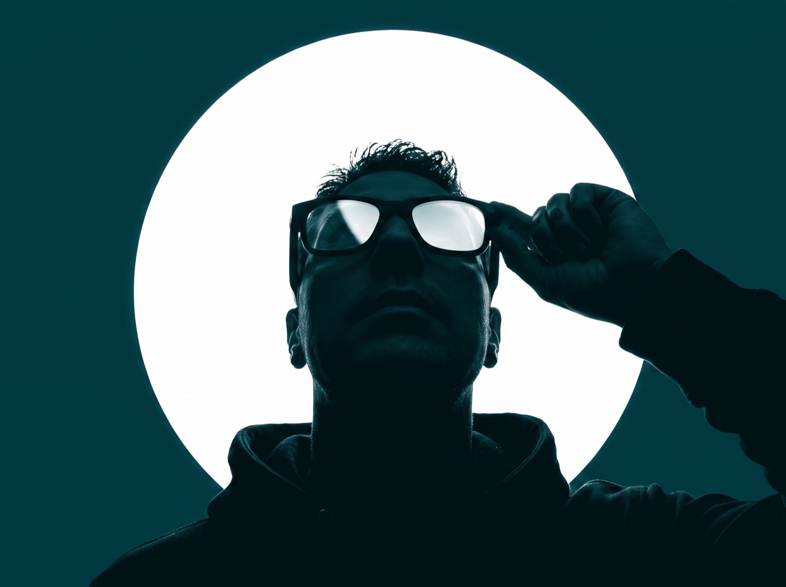 A man wearing Glimpse Glasses looks up at a bright white disc of light
